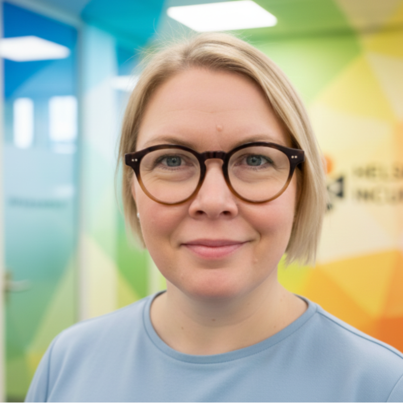 Elisa Kauria katsoo tässä kuvassa kameraan. Taustalla näkyy värikäs toimistotila.
